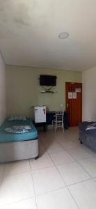ein Schlafzimmer mit zwei Betten und einem Fernseher an der Wand in der Unterkunft Pousada raios de sol indaia in Bertioga