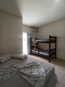 ein Schlafzimmer mit einem großen Bett und ein Zimmer mit einem Etagenbett in der Unterkunft Pousada raios de sol indaia in Bertioga + 114 Fotos