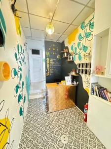 a room with a desk and a wall with flowers on it at Pupa Women Hostel in Patong Beach +6 photos