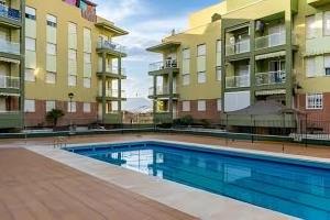 a swimming pool in front of two apartment buildings at Precioso piso Torrenueva con Piscina y cerca Playa in Torrenueva