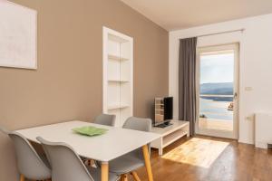 a dining room with a table and chairs and a window at Casa M Rabac in Rabac