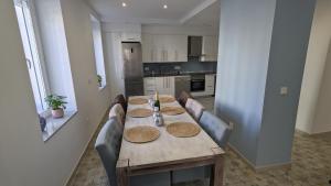 a kitchen with a wooden table with chairs around it at Casa EntreAzules l Vivienda Rural in Lecrin