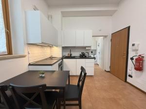 a kitchen with white cabinets and a table and chairs at Iris House - Rho Fiera in Rho