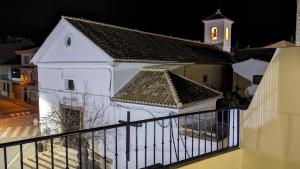 a small white church with a clock tower at night at Casa EntreAzules l Vivienda Rural in Lecrin