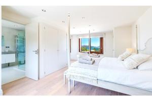a white bedroom with a large bed and a window at Villa Elvissa in Cielo de Bonaire 