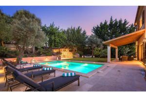 a swimming pool in a yard with chairs and a house at Villa Elvissa in Cielo de Bonaire 