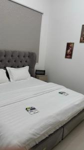 a large white bed with two pictures on it at شقة أرضية عائلية مكونة من غرفتين نوم وصالة ومطبخ 3 in Riyadh +20 photos