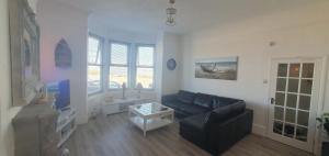 a living room with a couch and a table at Stunning Beachfront Apartment Sleeps 4 in Rhos-on-Sea