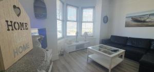 a living room with a couch and a table at Stunning Beachfront Apartment Sleeps 4 in Rhos-on-Sea