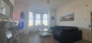 a living room with a couch and a tv at Stunning Beachfront Apartment Sleeps 4 in Rhos-on-Sea +45 photos