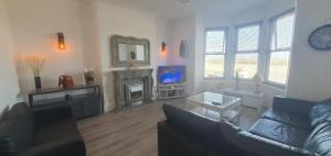 a living room with a couch and a fireplace at Stunning Beachfront Apartment Sleeps 4 in Rhos-on-Sea