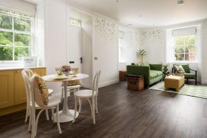 un salon avec une table et des chaises dans l'établissement Grooms Cottage, Kailzie, à Peebles