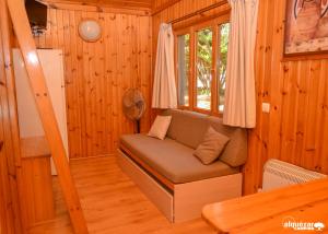 a living room with a couch in a wooden room at Camping Alquézar in Alquézar