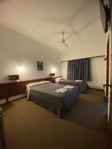 a hotel room with two beds and a window at Hotel Capri in Villa Gesell