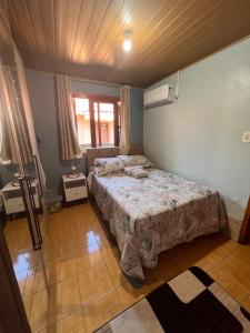 a bedroom with a bed in the corner of a room at Casa agradável, próximo a Gramado in Três Coroas