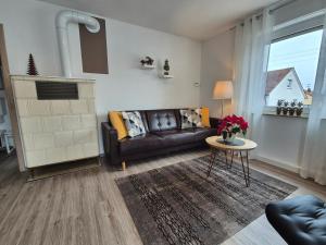 ein Wohnzimmer mit einem Ledersofa und einem Tisch in der Unterkunft Ferienwohnung S-Bahn Nähe in Schwaikheim