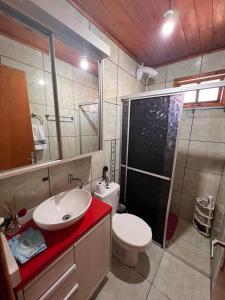 a bathroom with a toilet and a sink and a shower at Casa agradável, próximo a Gramado in Três Coroas +18 photos