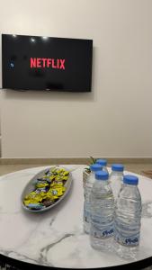 three bottles of water and a plate of food on a table at شقة أرضية عائلية مكونة من غرفتين نوم وصالة ومطبخ 3 in Riyadh