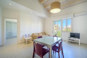 Una sala de estar con una mesa y sillas y un sofá. en Talete, appartamento in centro a 40 mt dalla spiaggia - Pomelia, en Marina di Ragusa