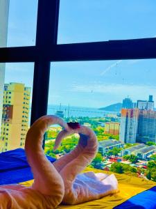 two swans making a heart in front of a window at Deluxe Suites with Infinity Pool, Kids' Pool & Sea in Jelutong