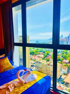 a room with a large window with a flamingo on a bed at Deluxe Suites with Infinity Pool, Kids' Pool & Sea in Jelutong
