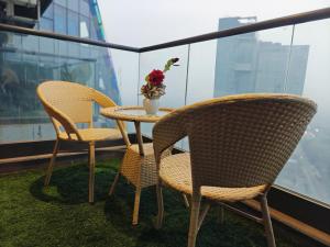 two chairs and a table with a vase of flowers on a balcony at Luxurious suite with City view in Ghaziabad