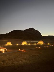a group of tents in the desert at night at HOlIDAY LUXURY WADI RUM in Wadi Rum