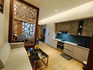 a living room with a couch and a kitchen at Luxurious suite with City view in Ghaziabad