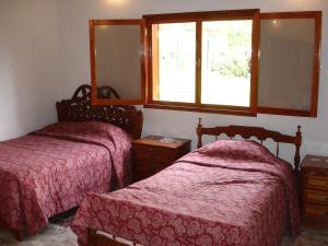 a bedroom with two beds and a mirror and a window at Swiss Chalet en Canta in San Miguel