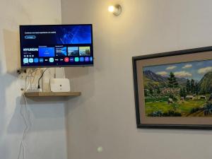 a flat screen tv on a wall next to a picture at Swiss Chalet en Canta in San Miguel