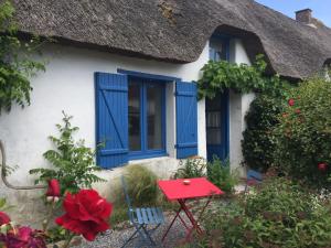a cottage with a blue window and a red table at Linotte Chaumière des Marionnettes in La Chapelle-des-Marais +7 photos