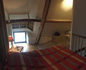 an attic room with a bed and a window at Linotte Chaumière des Marionnettes in La Chapelle-des-Marais