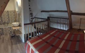 a bedroom with a bed and a stair case at Linotte Chaumière des Marionnettes in La Chapelle-des-Marais