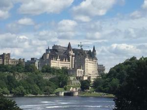 a large building on a hill next to a river at Linotte Chaumière des Marionnettes in La Chapelle-des-Marais