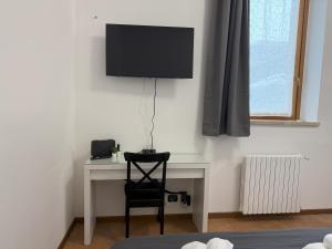 a room with a desk with a television on a wall at Iris House - Rho Fiera in Rho