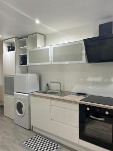 a kitchen with a sink and a washing machine at Studio neuf avec terrasse et entrée indépendante in Élancourt +19 photos