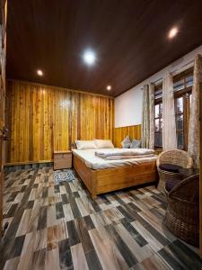 une chambre avec un grand lit et des murs en bois dans l'établissement Payun Homestays, à Darjeeling