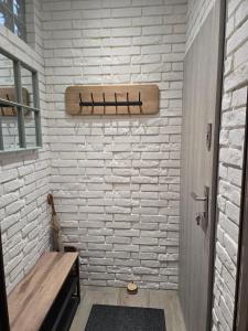 a bathroom with a white brick wall and a wooden bench at TROPIC-APARTAMENTY in Hel +7 photos
