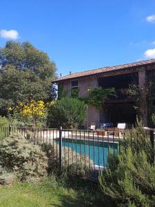 a house with a fence around a swimming pool at La Lepre Bianca in Cento