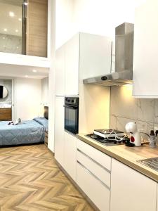 a kitchen with white cabinets and a bed at Gold suite19 in Catania