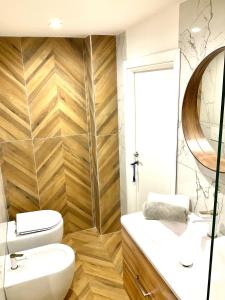 a bathroom with a toilet and a sink and a mirror at Gold suite19 in Catania