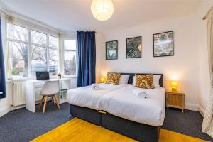 a bedroom with a large bed and a desk at University View-Off-Street Parking-Sleeps 8-Fast WiFi in Nottingham