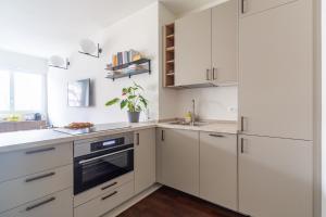 a white kitchen with white cabinets and a sink at Charming & Bright Apartment near Milan's Fashion District in Milan