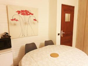 Zimmer mit einem Tisch, Stühlen und einer Tür in der Unterkunft Chambre Cosy bien équipée proche RER aux Portes de Paris in Stains