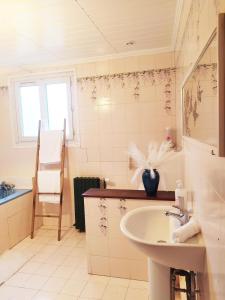 ein weißes Badezimmer mit Waschbecken und Fenster in der Unterkunft Chambre Cosy bien équipée proche RER aux Portes de Paris in Stains