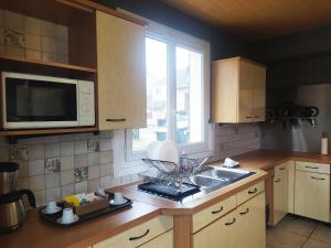 eine Küche mit Spüle und Mikrowelle in der Unterkunft Chambre Cosy bien équipée proche RER aux Portes de Paris in Stains + 14 Fotos