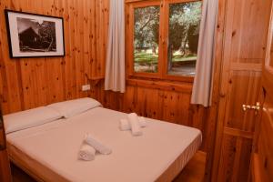 a bed in a wooden room with two towels on it at Camping Alquézar in Alquézar +89 photos