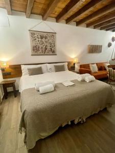 a bedroom with a large bed with two towels on it at La Casa del Cantero in Pinilla del Valle
