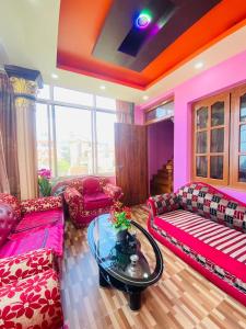 a living room with pink couches and a glass table at Biva's Home, Kathmandu in Thimi