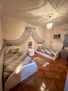 a bedroom with two beds and a chandelier at Luxury Lodge for Men in Cairo